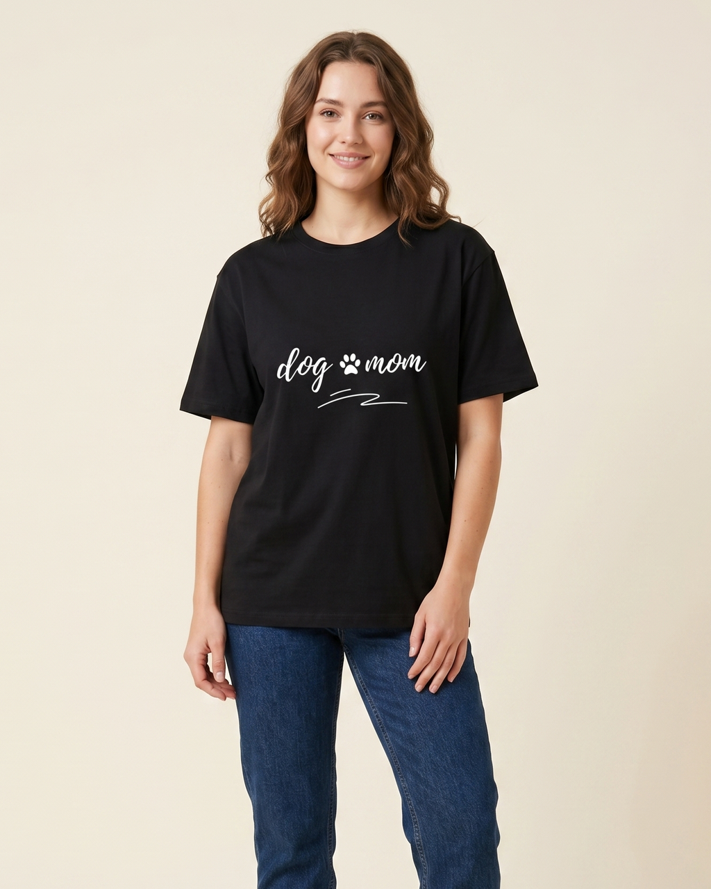 Woman wearing a black t-shirt with 'dog mom' text on a beige background