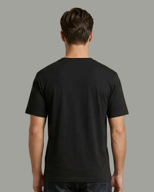 Man wearing a black t-shirt and dark jeans on a grey background