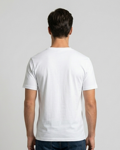 Person wearing a plain white t-shirt and dark jeans on a light gray background