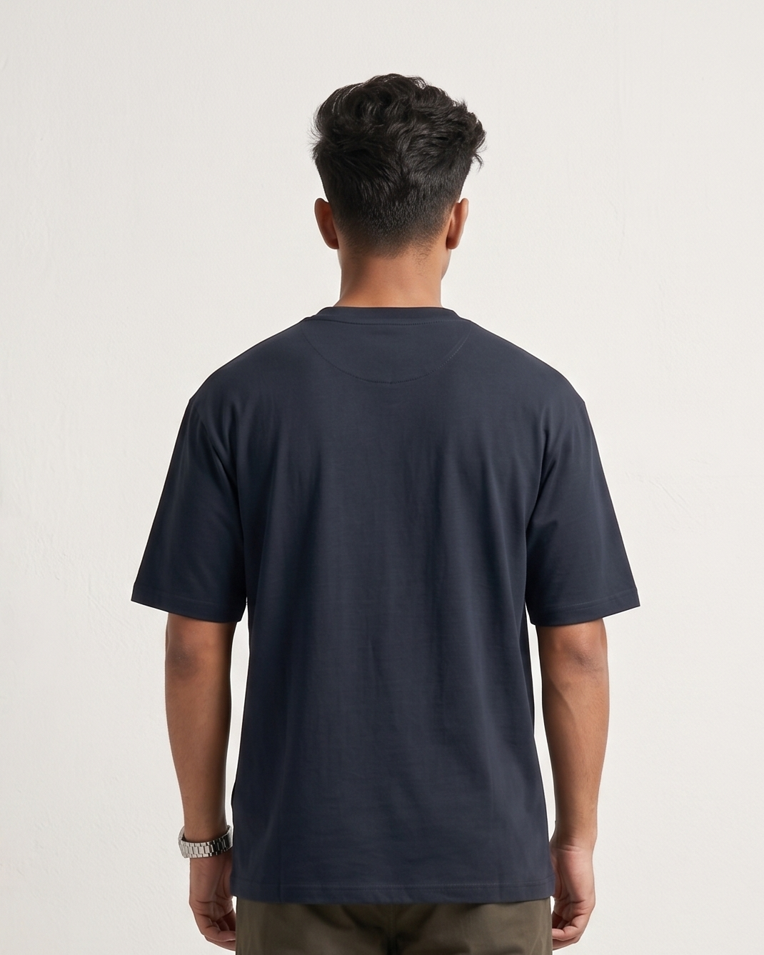 Person wearing a navy t-shirt and green cargo pants on a white background