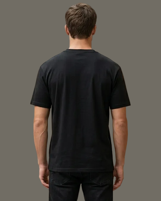 Man wearing a black t-shirt and pants standing in a modern clothing store.