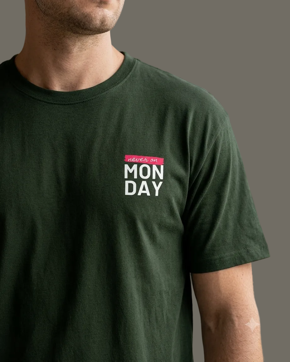 Person wearing a green t-shirt with 'Monday' text on a grey background