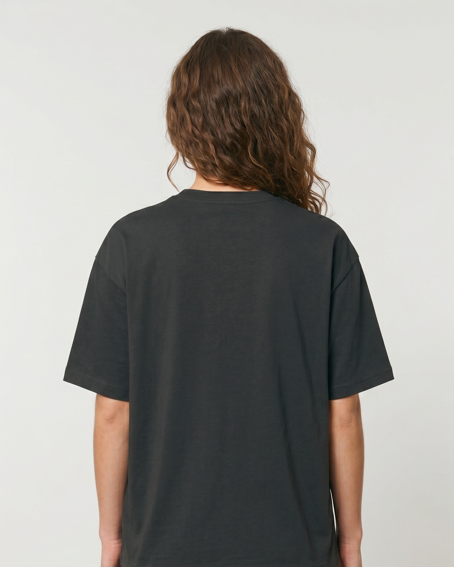 Person wearing a plain steel grey t-shirt on a light gray background