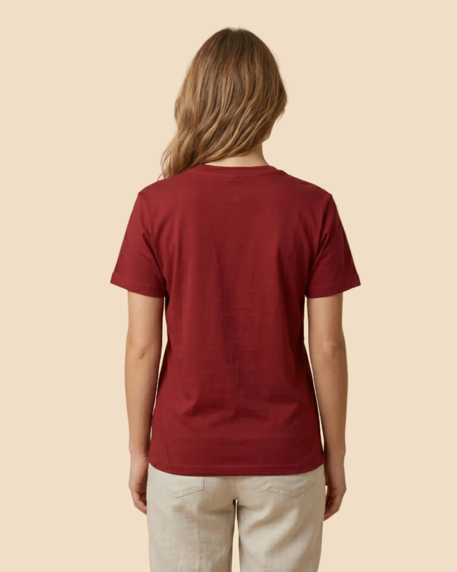 Person wearing a red t-shirt and beige pants on a beige background