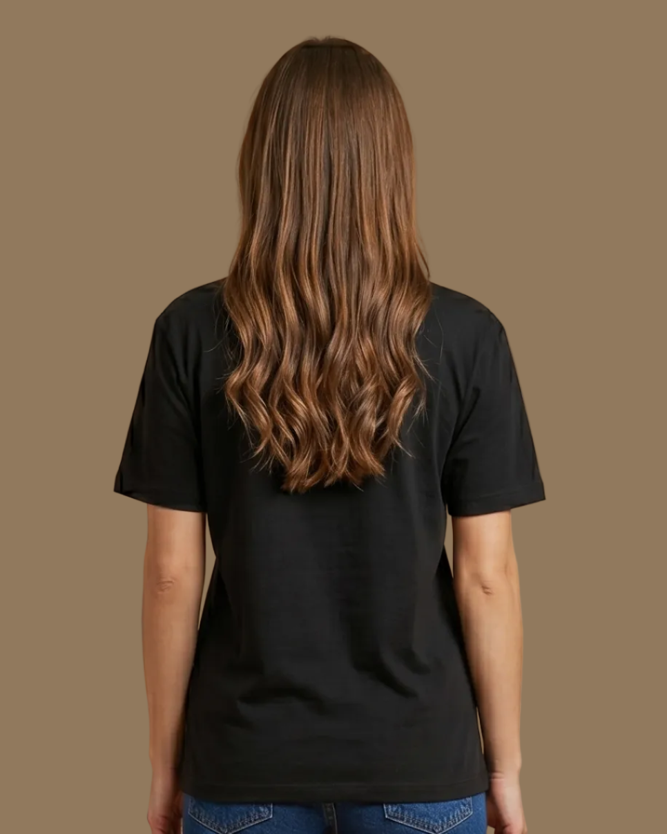 Person wearing a black t-shirt and blue jeans on a beige background