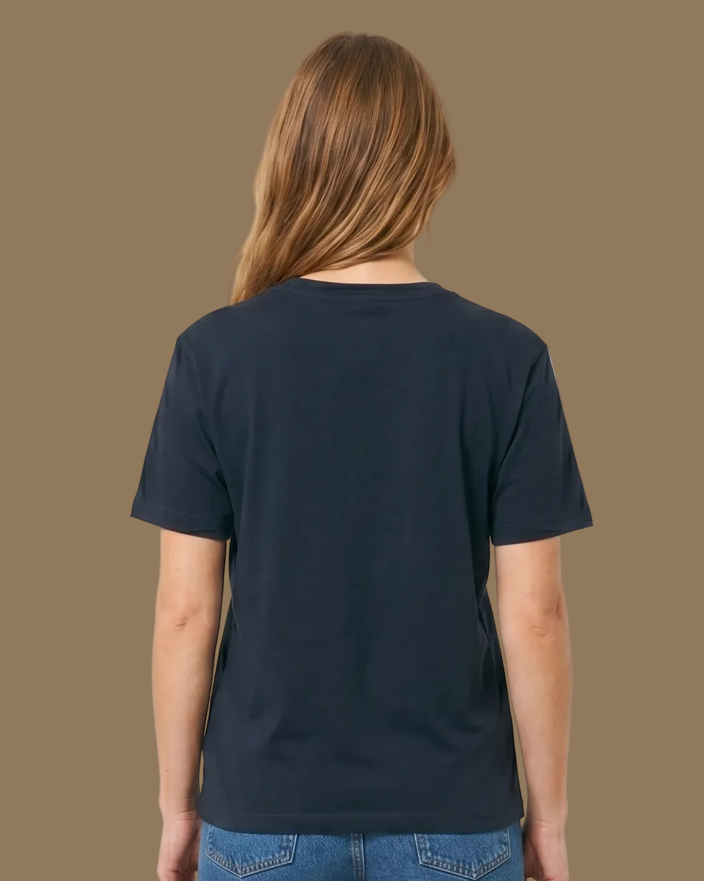 Person wearing a navy t-shirt and blue jeans on a beige background