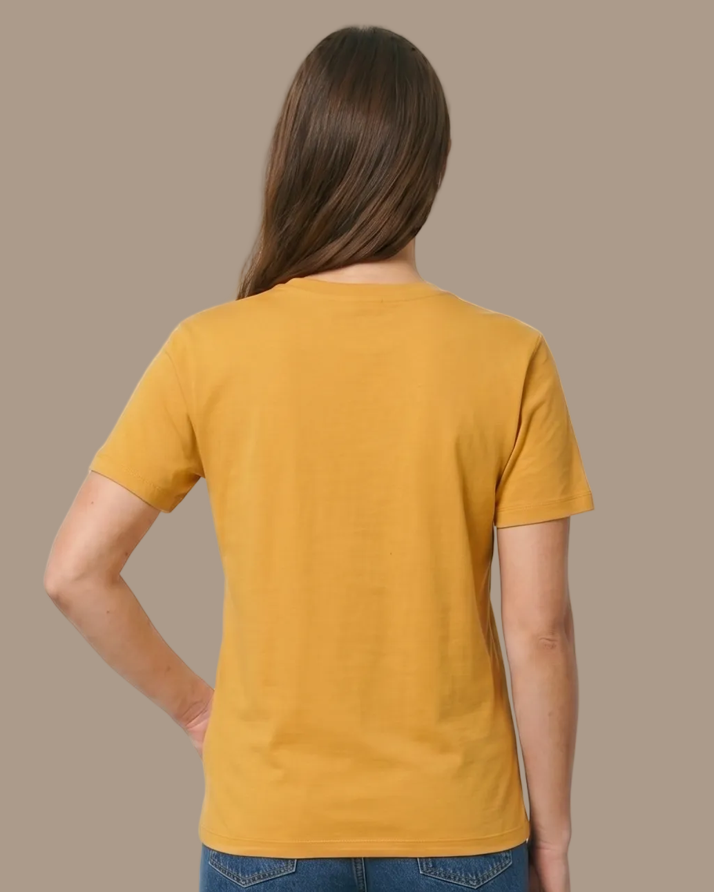Person wearing a mustard yellow t-shirt and blue jeans on a plane background
