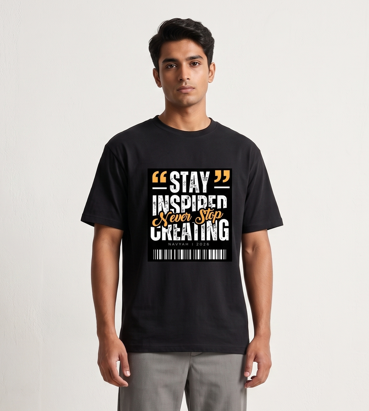Person wearing a black t-shirt with text and gray pants on a white background