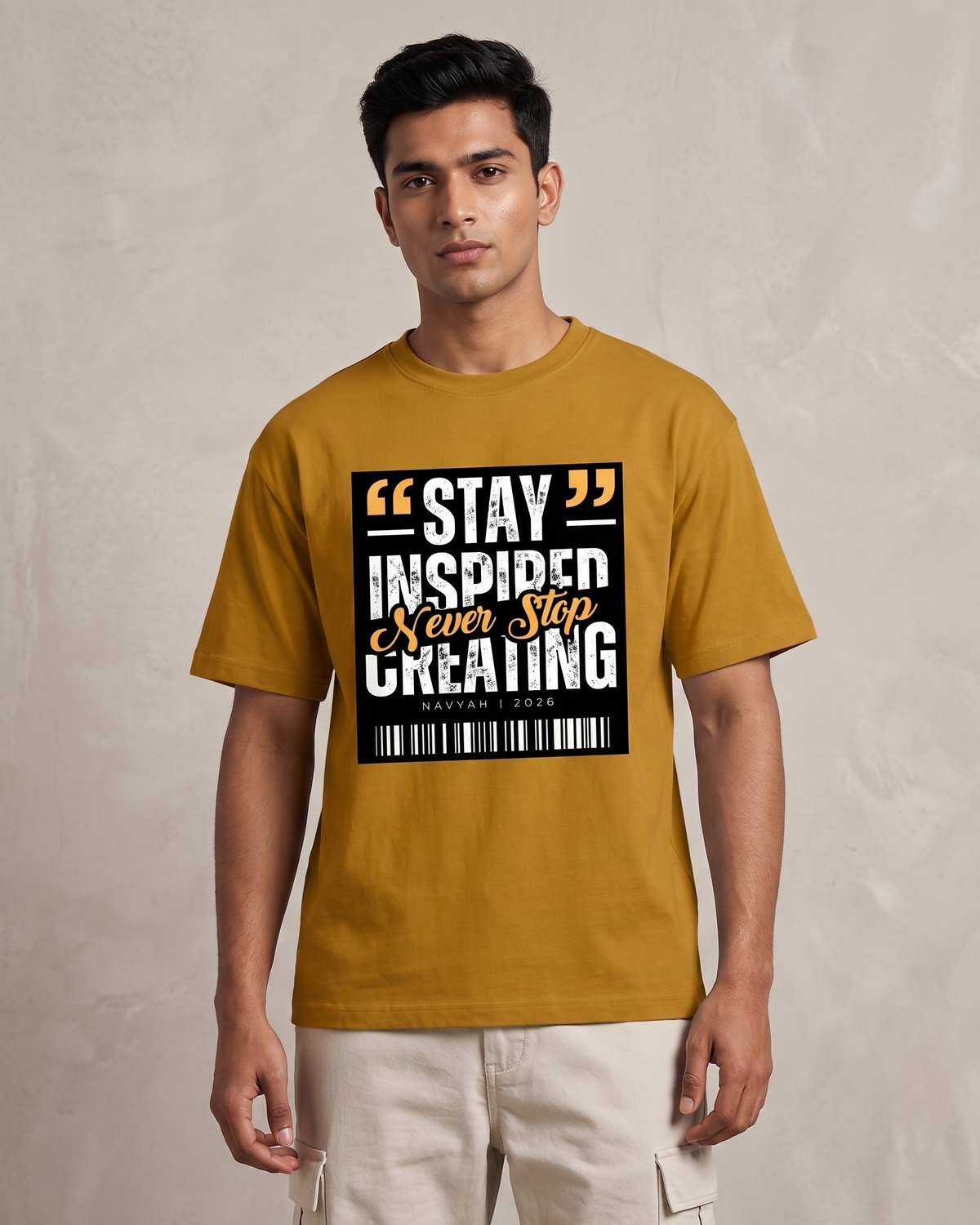 Man wearing a mustard yellow t-shirt with motivational quote design on a plain background