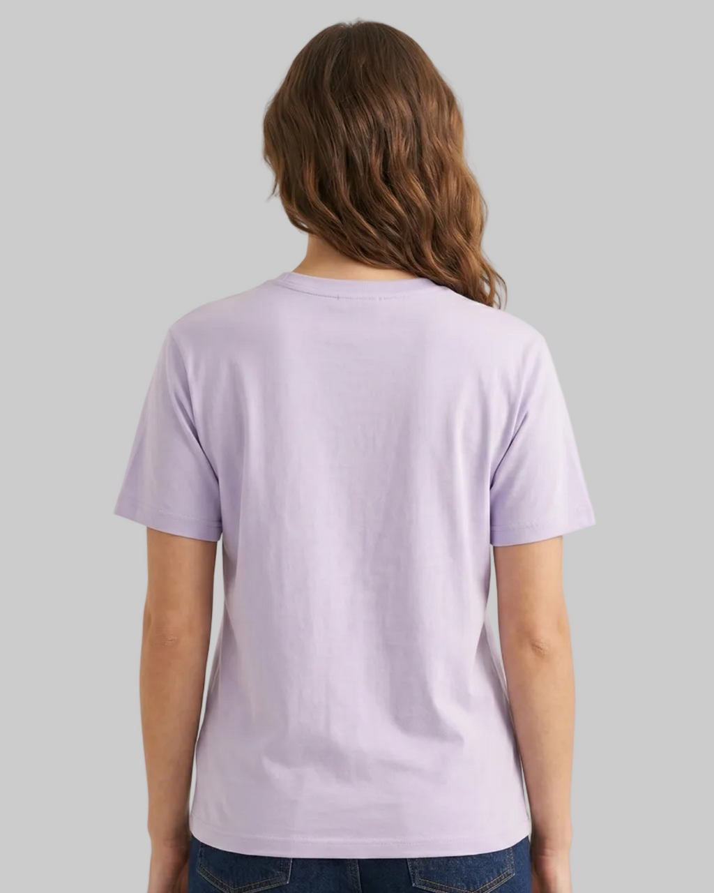 Person wearing a light purple t-shirt and blue jeans on a plain background
