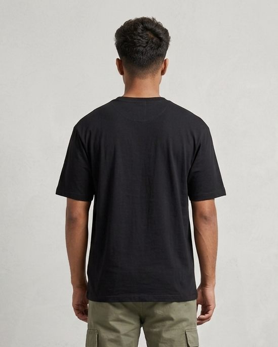 Person wearing a black t-shirt and green cargo pants on a plain background