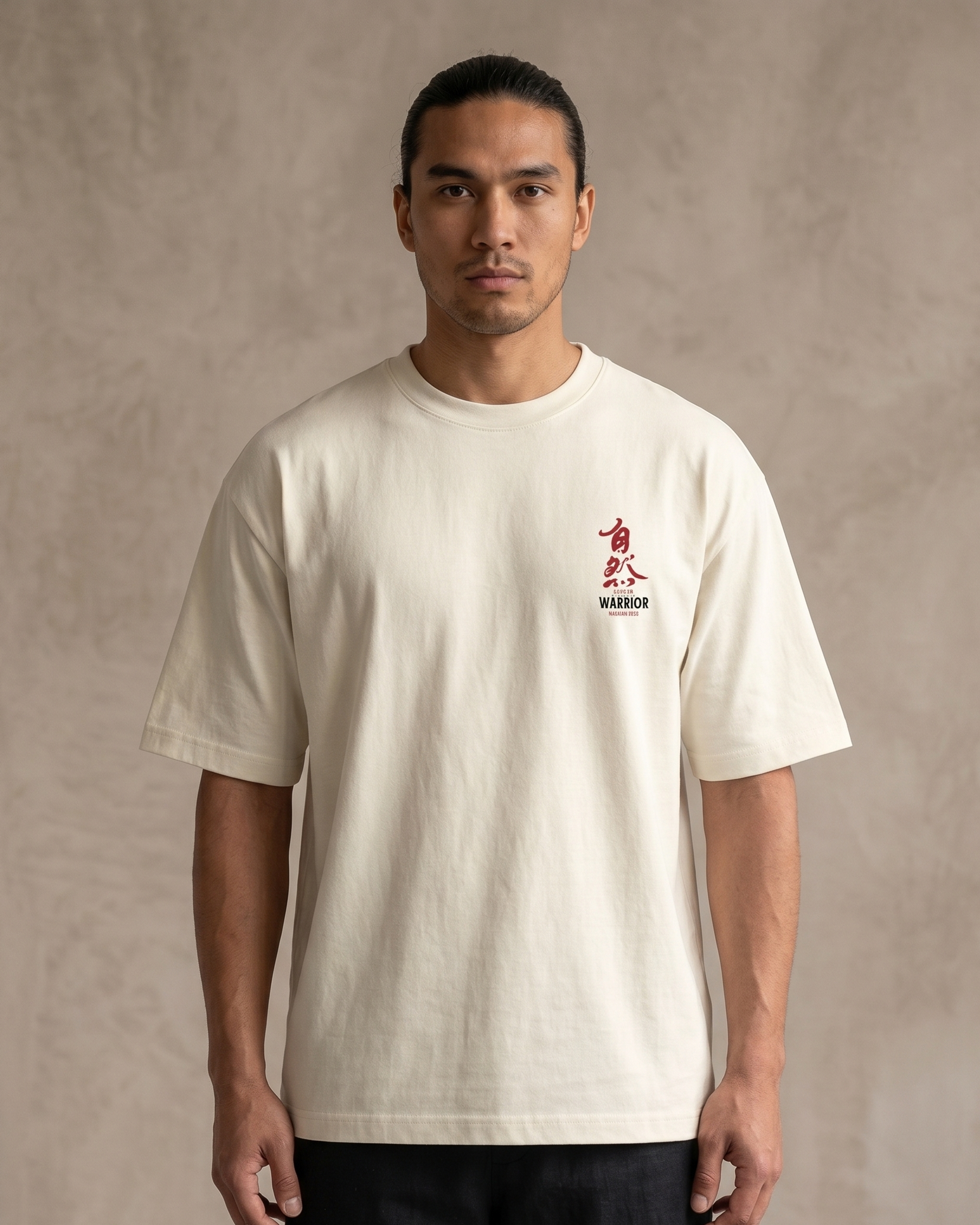 Man wearing a beige t-shirt with red and black text on a plain background